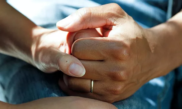 Patient holding his wife's hand